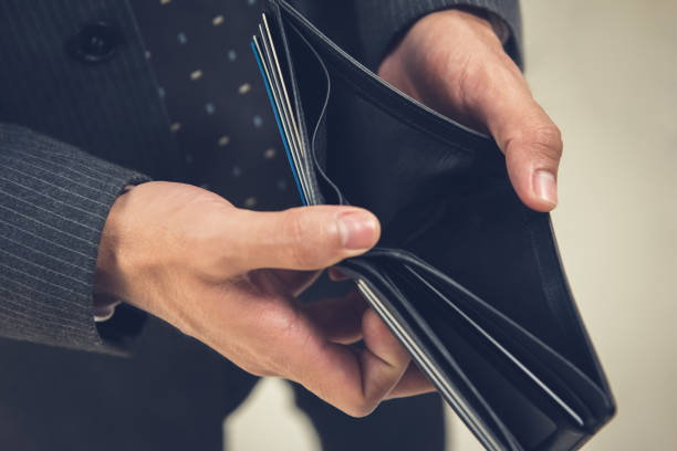 istock Broke businessman opening empty wallet 1136917680