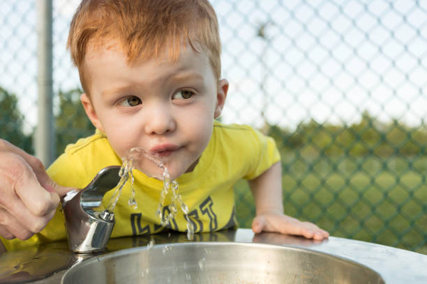 Cute Redhead Boy Drinking Water From Water Fountain