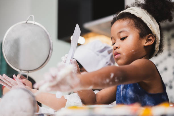 istock Group diversity kids girl making cake bakery in kitchen 1136930012