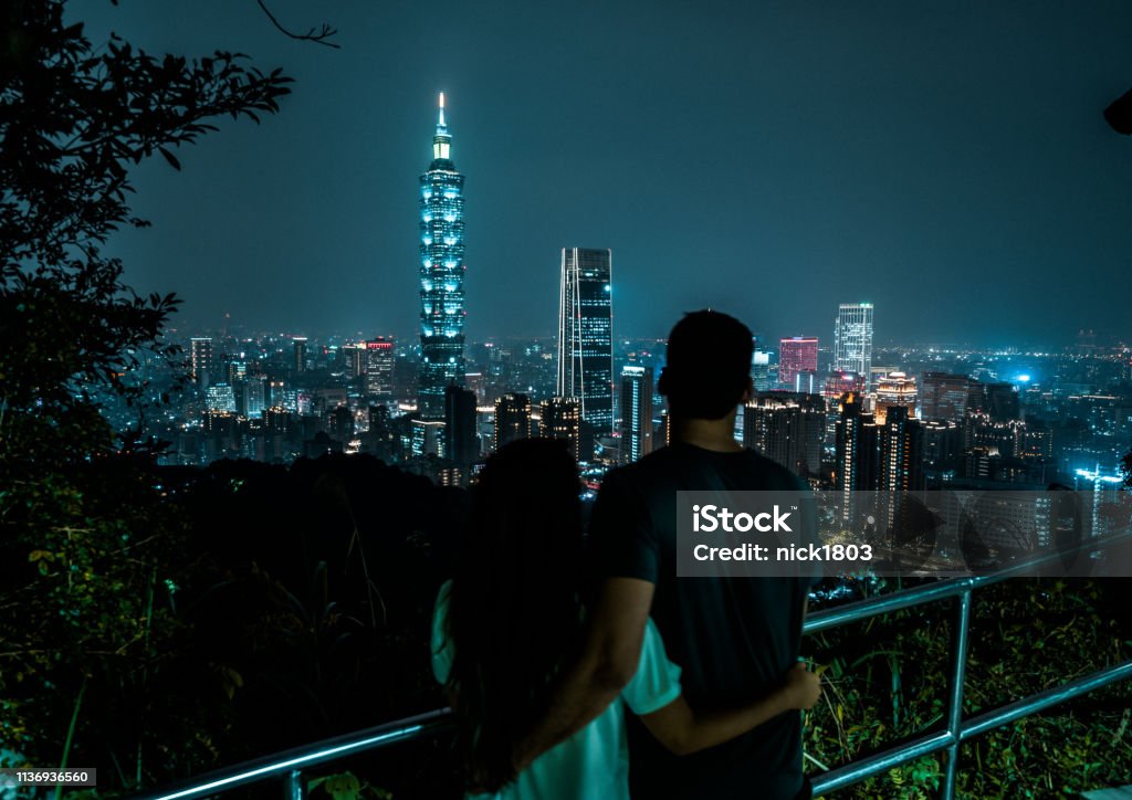 คู่รักสามารถมองเห็นเส้นขอบฟ้าที่สดใสของไทเปในเวลากลางคืน เมืองหลวงของไต้หวัน  ภาพสต็อก - ดาวน์โหลดรูปภาพตอนนี้ - Istock