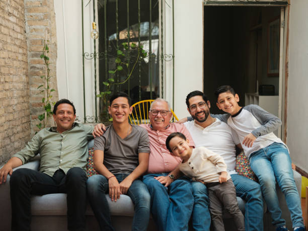 Mexican men and boys sitting together on sofa