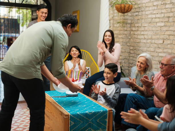 istock Mexican man bringing birthday cake to happy boy 1136937795
