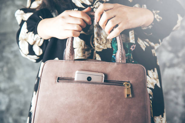 istock woman hand phone with bag pocket 1136937909