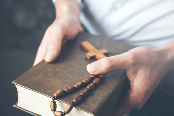 istock man hand holding  cross with Bible 1136937910