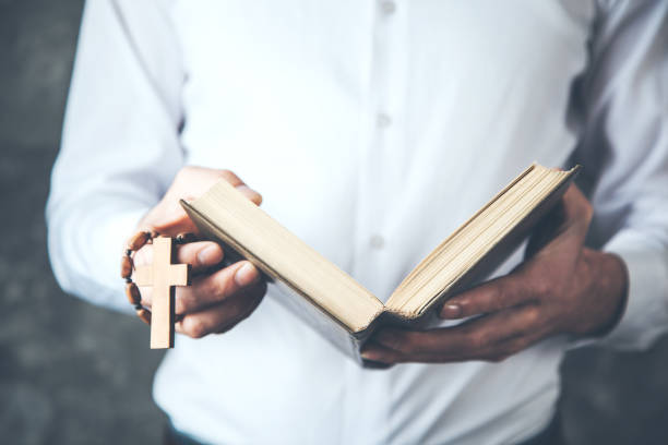 istock man hand cross with book on dark background 1136937924