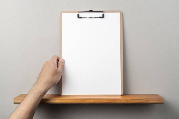 istock man's hand hold A4 paper with clipboard 1136939199