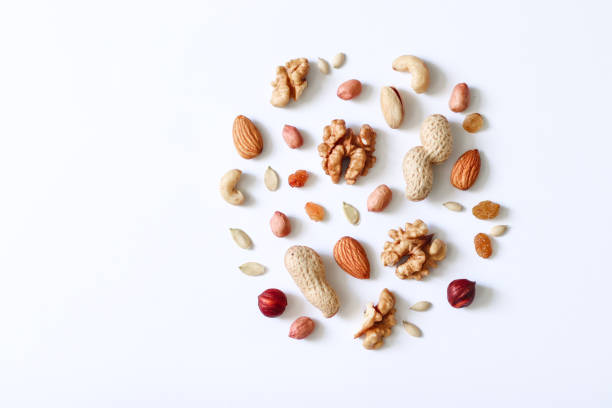 istock Hazelnuts, cashews, peanuts, walnuts, almonds, seeds lie on a white table.Assorted nuts on a white table. . 1136939763