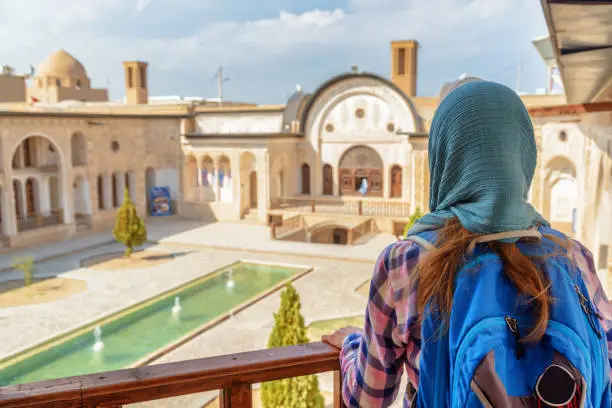 Photo of Female tourist enjoying view of traditional Iranian courtyard