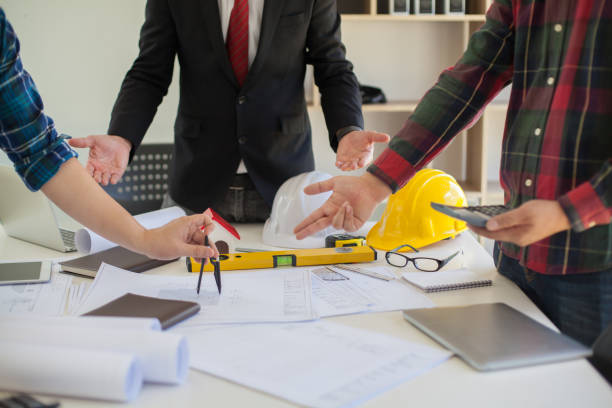 istock Concept Agreement between the employer and architect Nick and desk of Architectural project in construction site or office building with mining light 1136944302