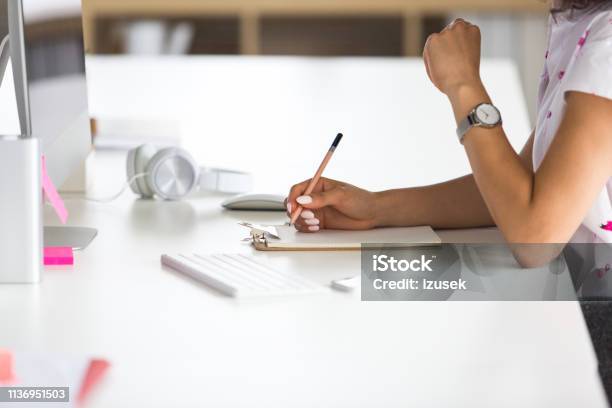 Woman Making Notes At Office Desk Stock Photo - Download Image Now - Clipboard, Computer, Women