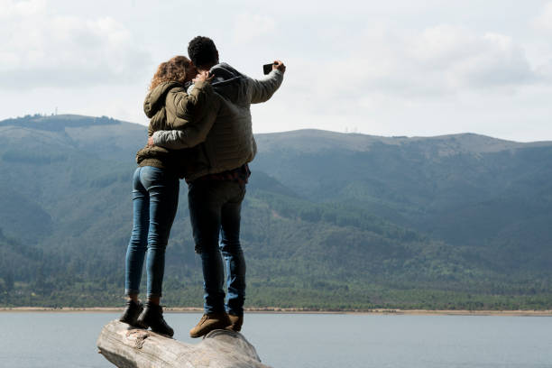 istock Couple sharing moments while watching the landscape and taking a selfie 1136952136