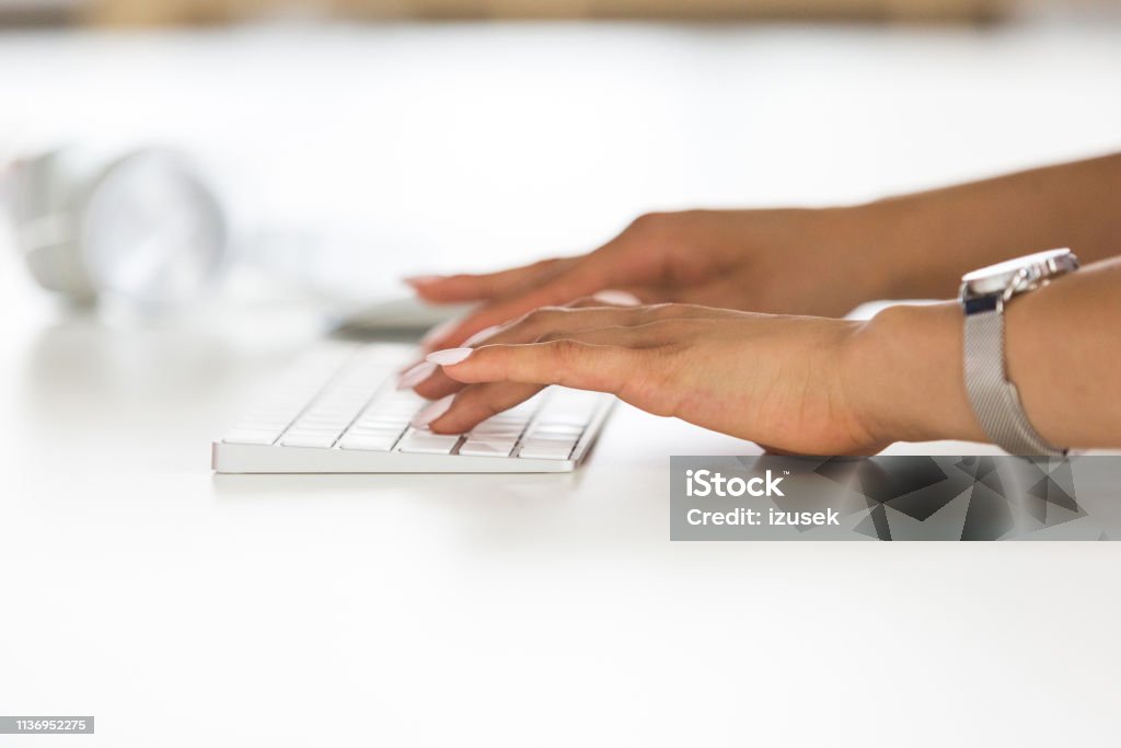 Female typing on keyboard Close up of woman working on computer. Focus on female hands typing on keyboard. Adult Stock Photo