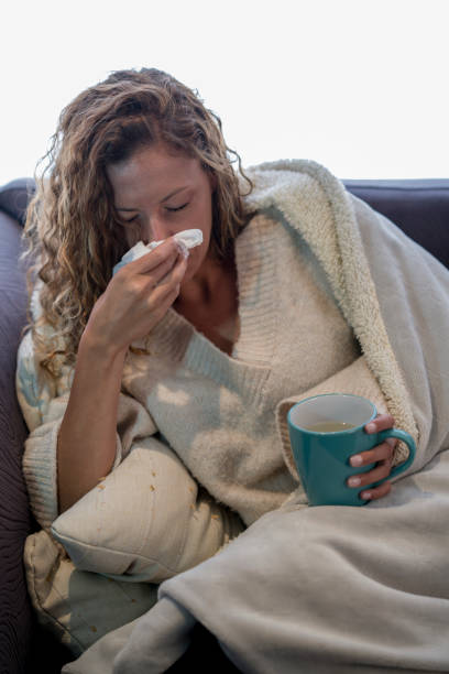 istock Woman sneezing from the flu 1136953428