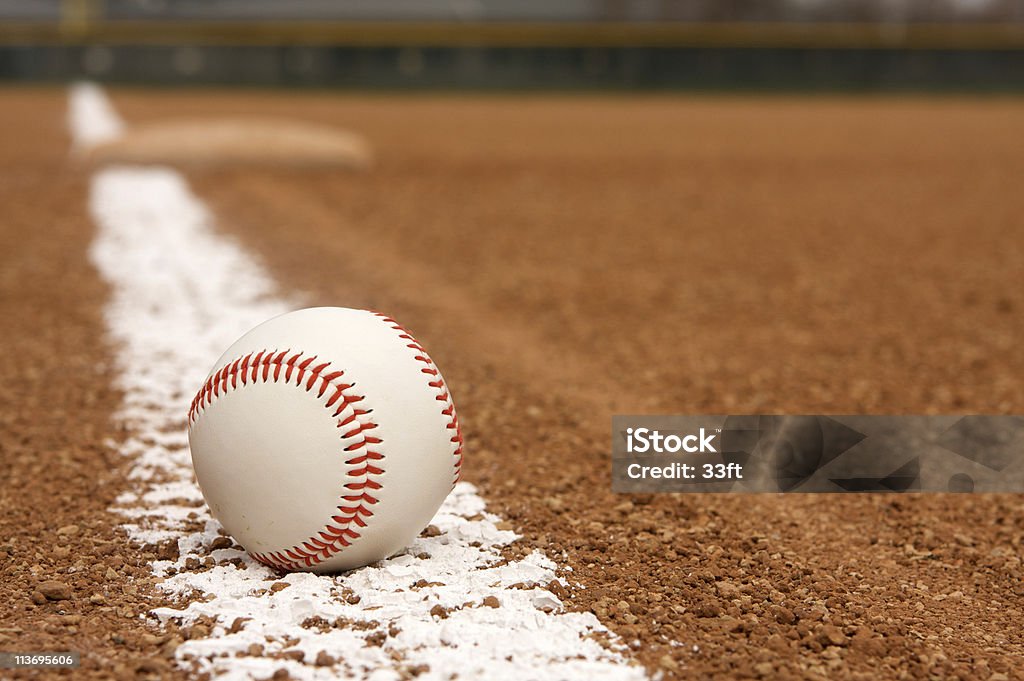 Baseball over chalk line of stadium field Baseball on the Infield Chalk Line with Third Base beyond Baseball Diamond Stock Photo