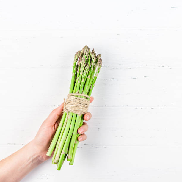 istock Fresh green asparagus in woman hands 1136958567
