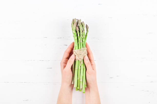 istock Fresh green asparagus in woman hands 1136958590