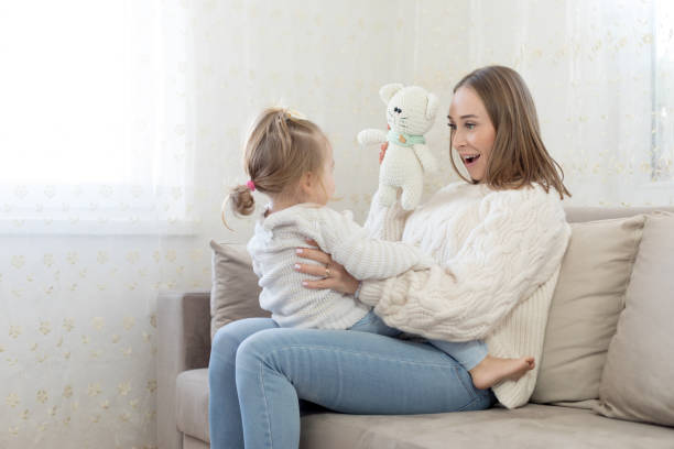 istock Mother and daughter having fun on sofa 1136966619