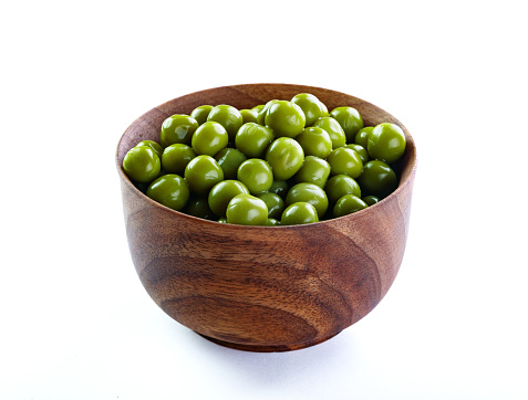 Green peas in wooden  bowl close up