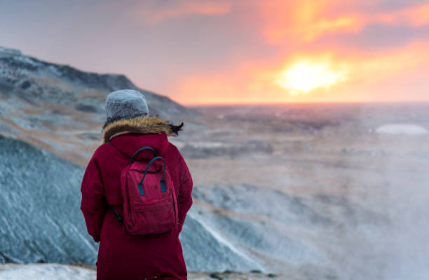 viajante fêmea em um hike do nascer do sol em islândia - rear view winter blizzard nordic countries - fotografias e filmes do acervo