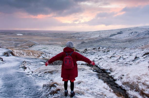 viajante fêmea em um hike do nascer do sol em islândia - rear view winter blizzard nordic countries - fotografias e filmes do acervo