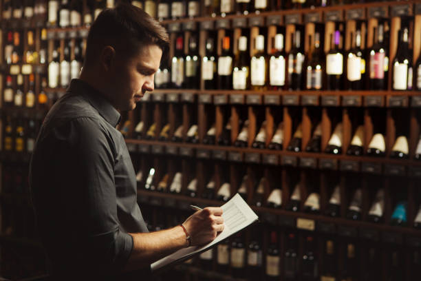 istock Sommelier writes at notes, putting down information on wine products in cellar 1136968858