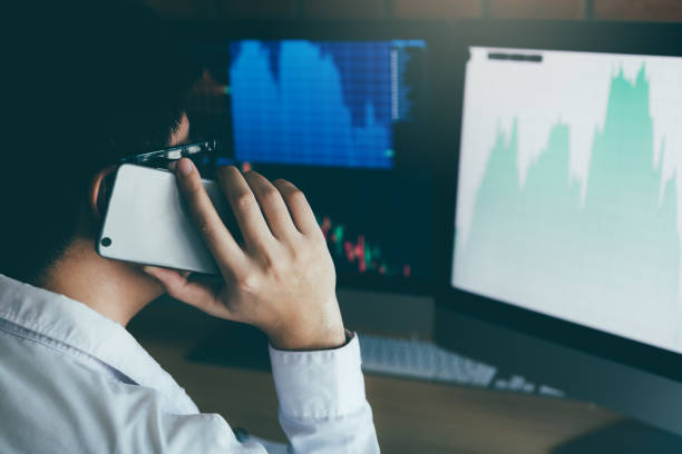 istock Asian agent trader man working and analysis in office and dealing with market financial charts and graphs and calling to customer. 1136973046