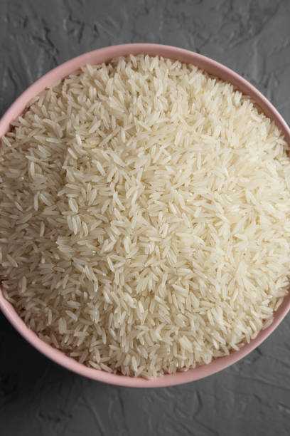 istock Dry white rice basmati in a pink bowl over gray surface, top view. Flat lay, overhead, from above. Close-up. 1136974006