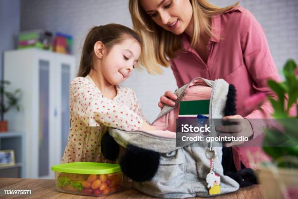 Young Mum And Daughter Packing Backpack For The School Stock Photo - Download Image Now