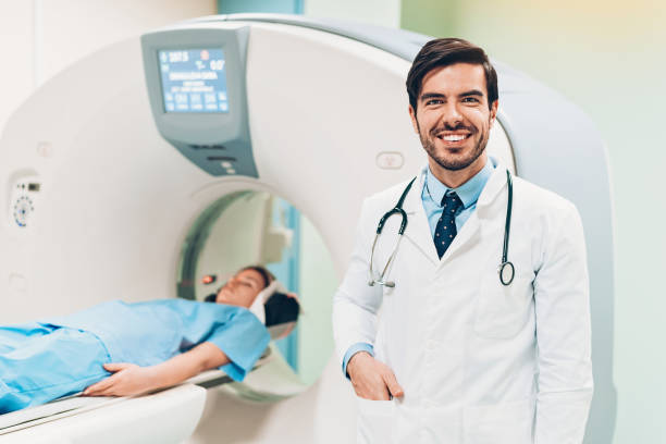 istock Smiling doctor standing next to modern diagnostic equipment 1136976251