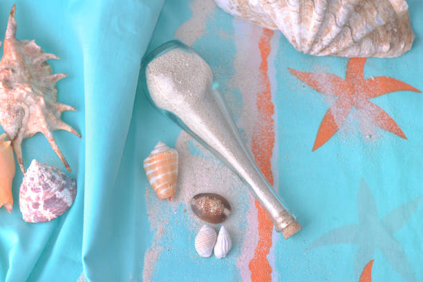istock sand in a little bottle and tropical seashells on a beach towel 1136976431