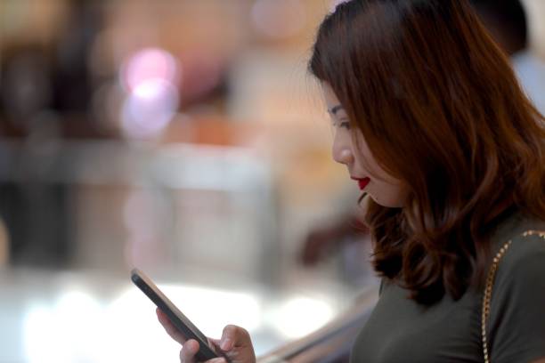 istock Young woman checking mail at shopping center 1136980948