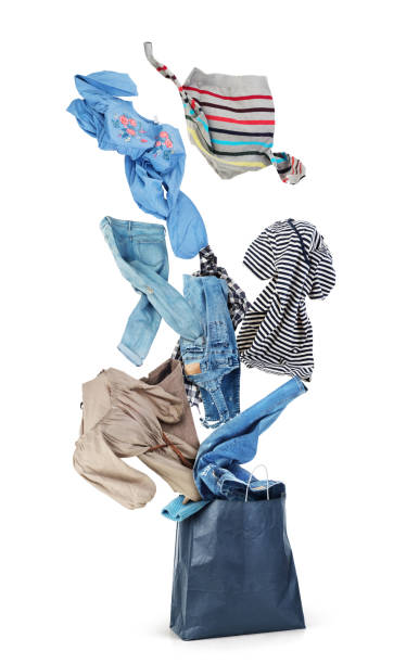 istock Clothing is flying from the paper bag on a white background 1136982106