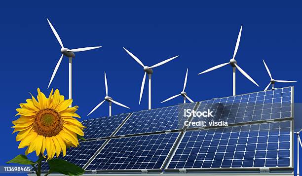 Monokristalline Solarmodule Windkrafträder Und Sonnenblume Vor Blauem Hintergrund - Fotografie stock e altre immagini di Ambiente