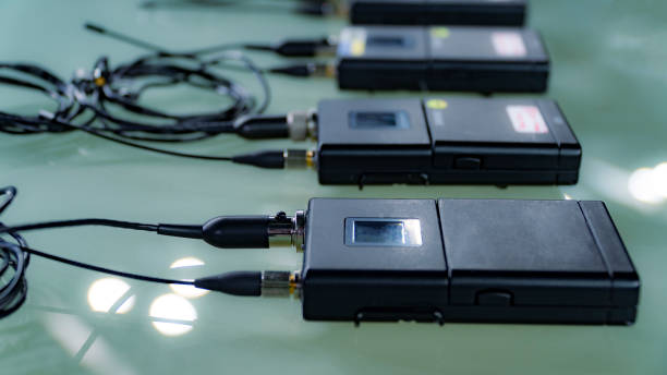 istock wireless microphone transmitter and wireless microphone reciever on glass table in tv studio 1136986589