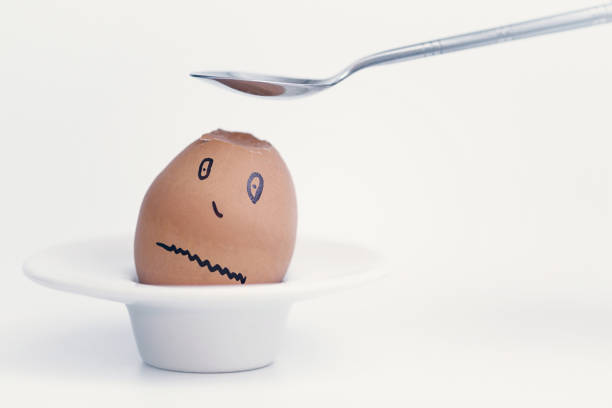 istock Spoon breaks sad egg on a stand in the form of human head . Concept. 1136987215