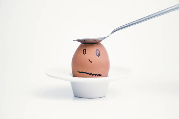 istock Spoon breaks sad egg on a stand in the form of human head . Concept. 1136987477