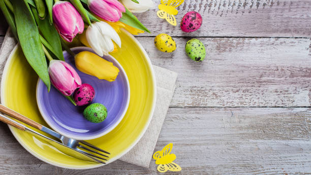 istock Easter table setting with spring tulips and cutlery. Holidays background. Top view, flat lay. copy space 1136988475