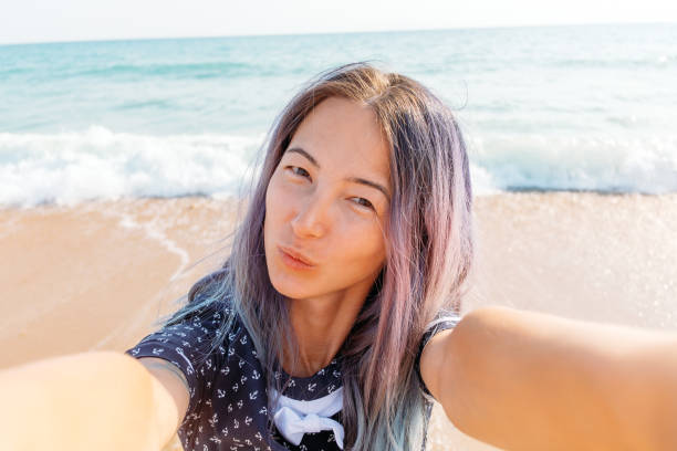 istock Girl taking selfie on sand beach. 1136992491