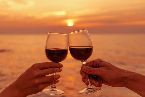 istock Couple clinking wine glasses at sea sunset. 1136992690