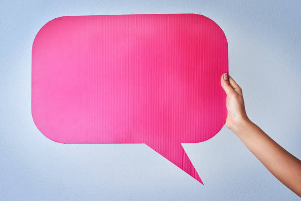 Shot of an unrecognizable woman holding up a speech bubble against a blue background