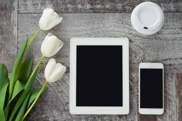 istock White tablet, phone, coffee and flowers are on the table. Work at home. Freelance. 1137001134