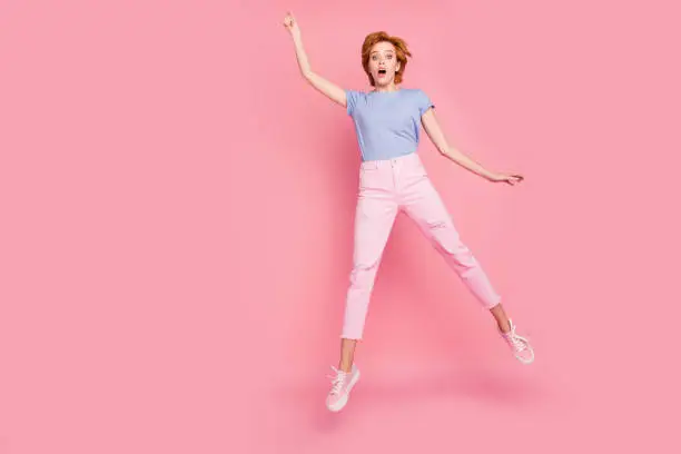 Photo of Full length body size view of her she nice cute charming attractive lovely feminine girl wearing casual jumping up in air wind blows having fun isolated on pink pastel background