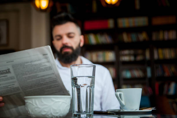 istock Young businessman with newspaper in cafe 1137004294
