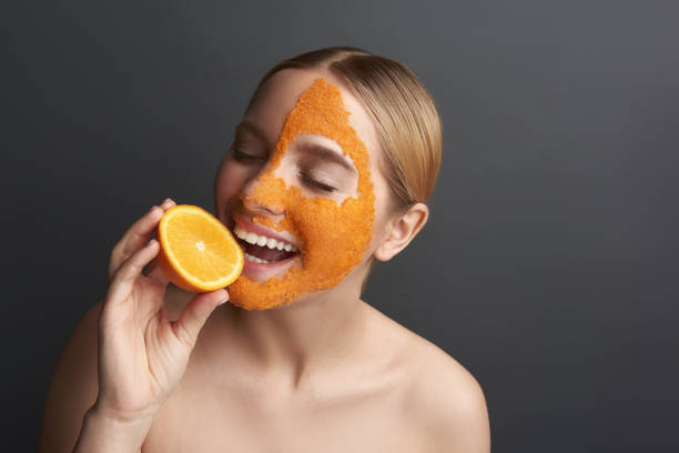 istock Happy lady biting slice of orange and smiling 1137006247