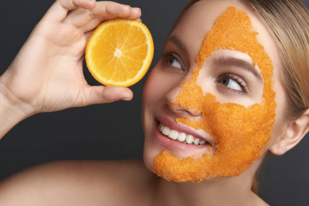 istock Pretty lady looking at fresh orange wheil having orange mask on her face 1137006250