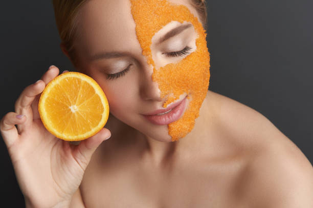 istock Woman with bare shoulders using orange peel mask and smiling 1137006272