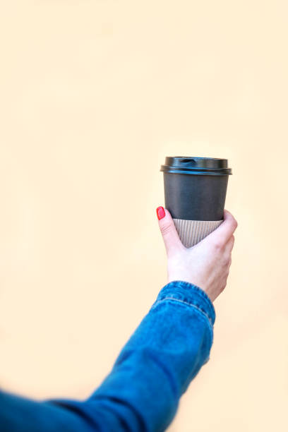 istock Young woman hand holding paper coffee cup. 1137006349