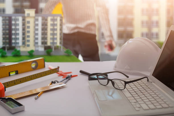 istock Concept Agreement between the employer and architect Nick and desk of Architectural project in construction site or office building  and Building models 1137007491