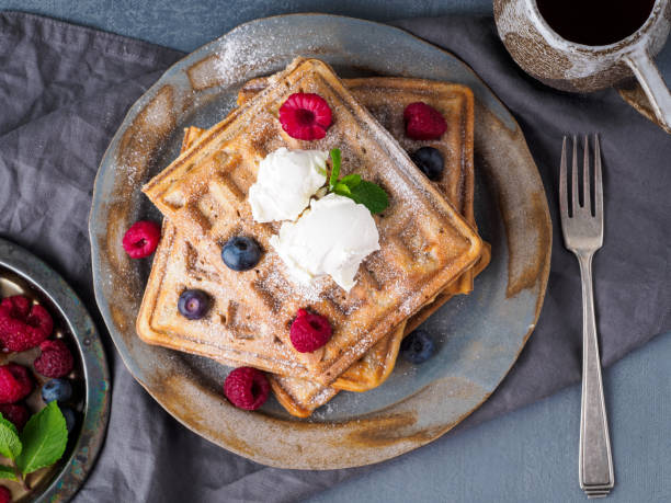 istock Belgian waffles with raspberries, chocolate syrup. Breakfast with tea on dark background, top view, close-up 1137010124
