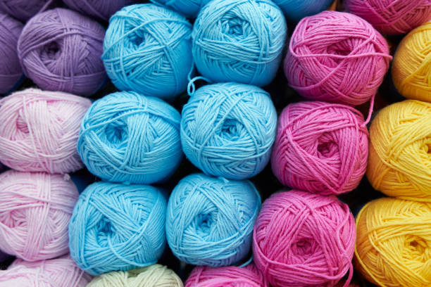 istock Threads for knitting different colors on the shelf in the store. Close up 1137011667